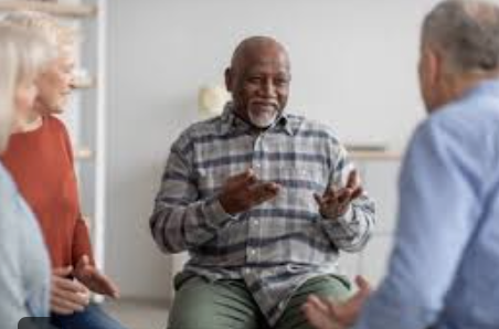 A photo of three seniors sitting in a circle having a discussion. 