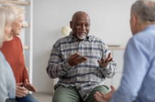 A photo of three seniors sitting in a circle having a discussion. 